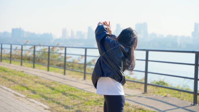 Woman stretching by the riverside