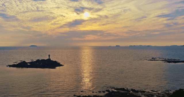 멀리 등대가 보이는 바다의 일몰