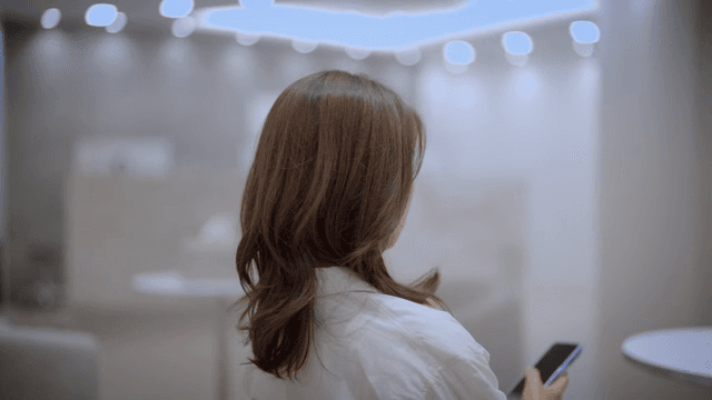 현대적인 라운지에서 스마트폰을 하며 기다리는 여성