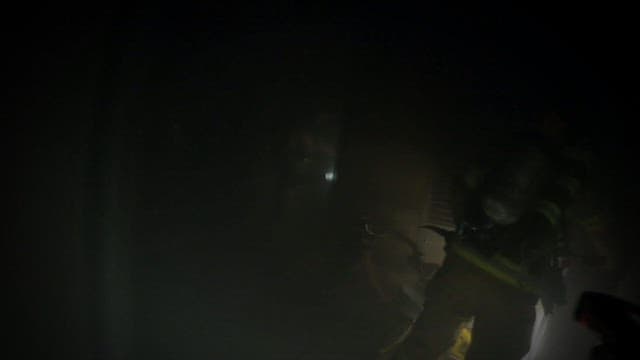 어둠과 연기로 가득한 실내로 진입하는 소방관들