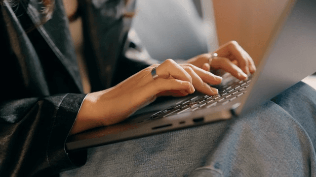 Person typing on a laptop keyboard