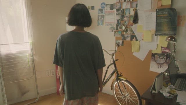 햇빛이 비치는 방에서 자전거 운동을 하는 여성