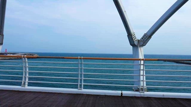 평화로운 해변가와 다리의 철제 난간