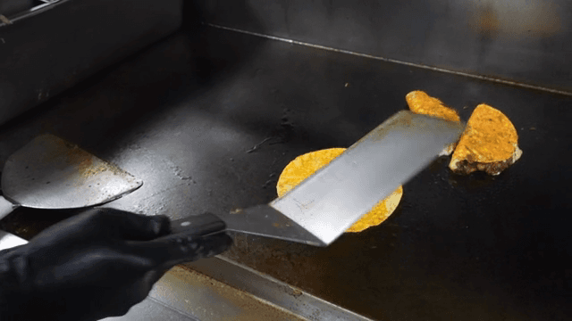 A taco being cooked on a hot griddle