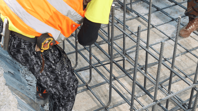 Worker tying rebar at a construction site