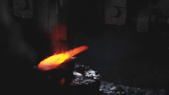 Hot metal forged quickly in workshop