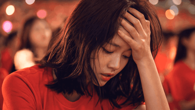 Woman wearing red T-shirt looking stressed