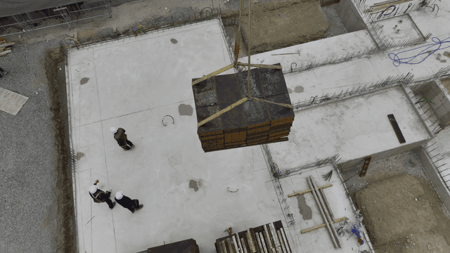 크레인 하중을 안내하는 건설 작업자들