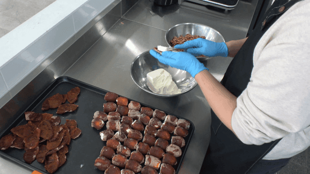 Person preparing cream cheese and dried persimmons