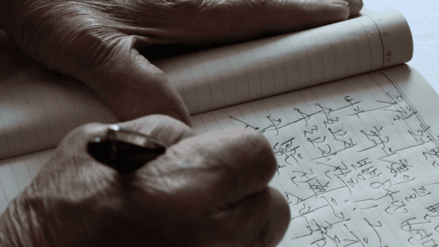 노트에 글을 쓰는 노인