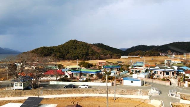 View of a quiet village with hills and yellow fields