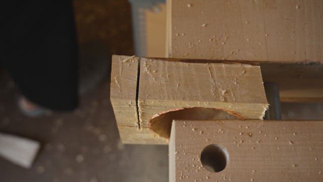 Wood being cut with a saw on a workbench