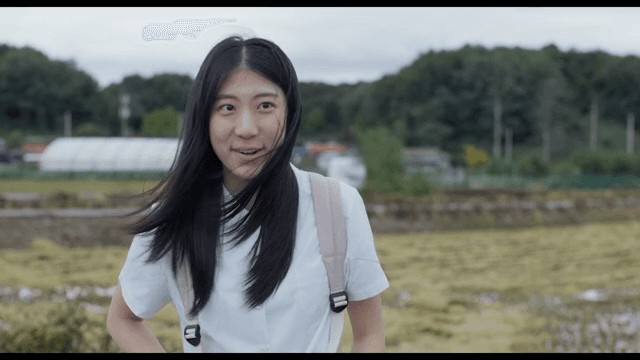 시골 들판에 서 있는 젊은 여성