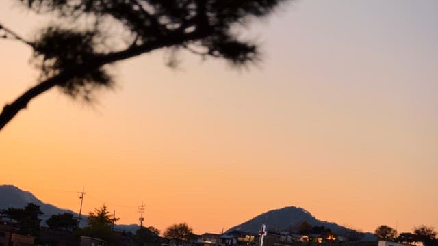 산 뒤에서 주황빛으로 물드는 석양