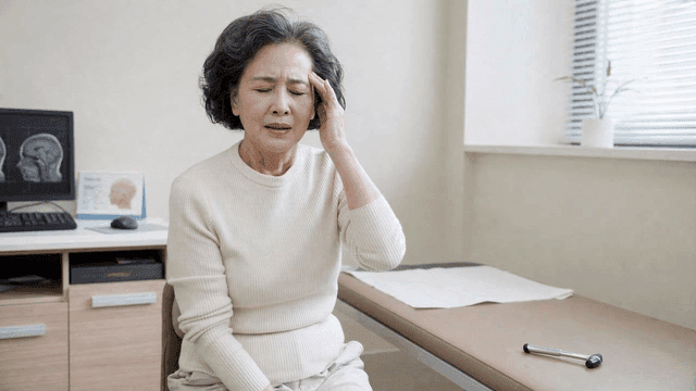 Elderly female patient suffering from headaches at clinic