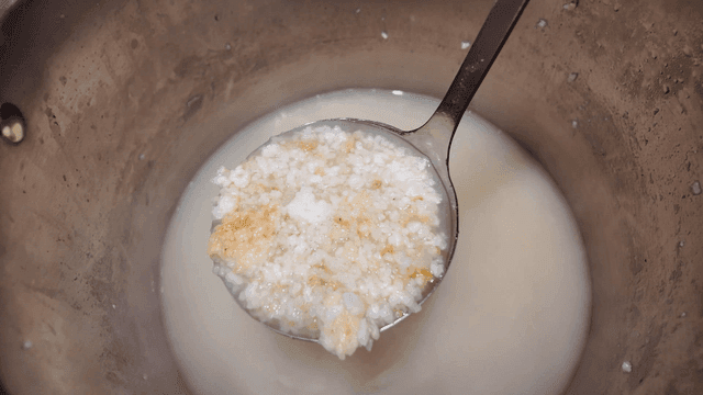 Rice water scooped out of pot to brim