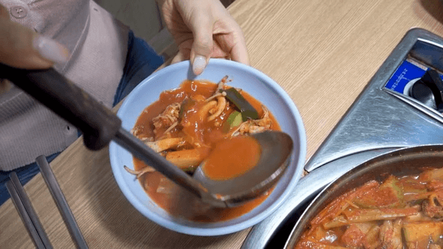 매운 한국 찌개를 그릇에 담는 모습
