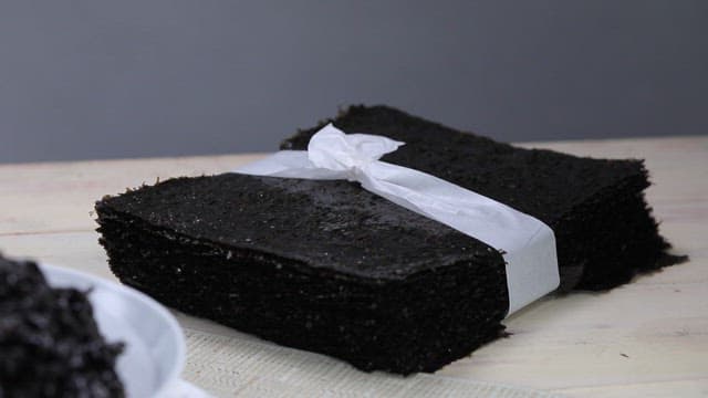 Bundle of black seaweed on the table and laver on a plate