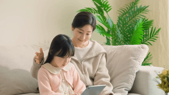 Mother and daughter using a tablet on a sofa