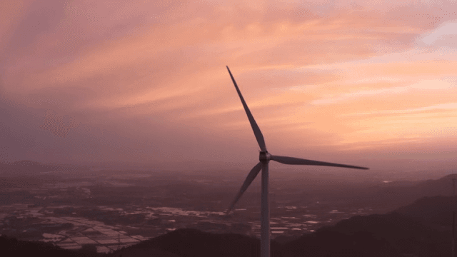 핑크빛으로 물들은 하늘 아래 산악 지역의 풍력 터빈