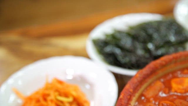 다양한 반찬과 함께 플레이팅된 매운 돼지찌개