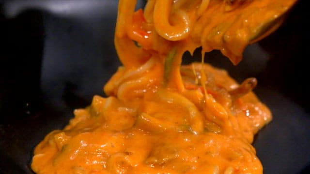 Creamy rose pasta being served in a bowl