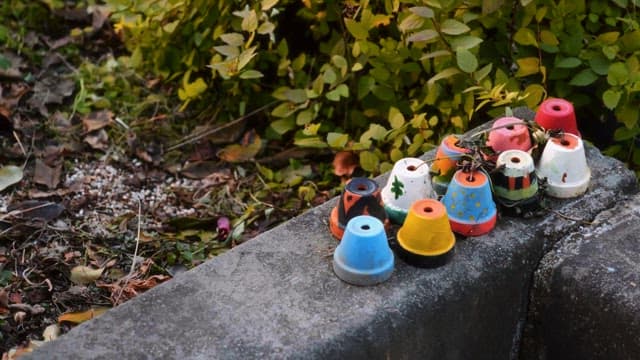 Painted flowerpots arranged on a concrete ledge