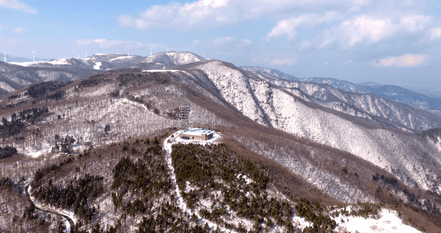Snow-covered mountains with wind turbines