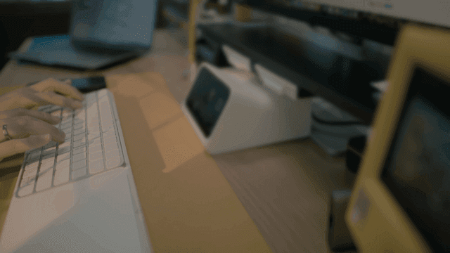 Hands typing on keyboard in front of monitor