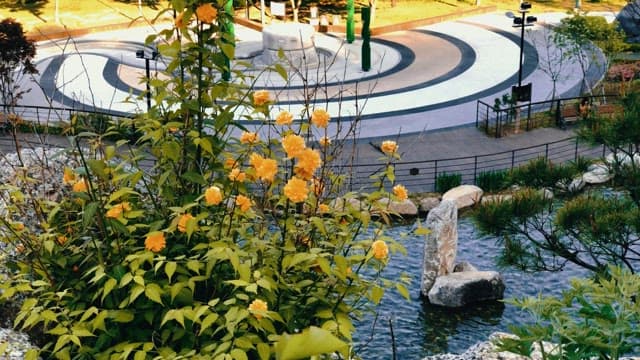 원형 구조물이 있는 고요한 공원의 노란 꽃