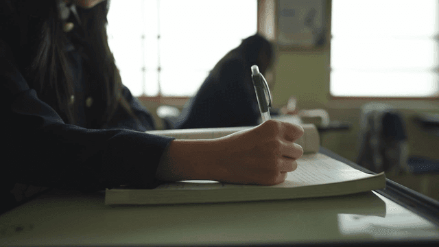 교실에서 노트 필기하는 학생