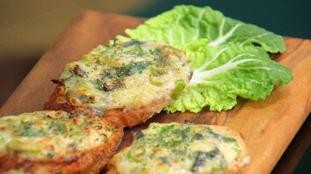 나무 도마 위에 바삭하고 먹음직스러운 파가 올라간 바게트