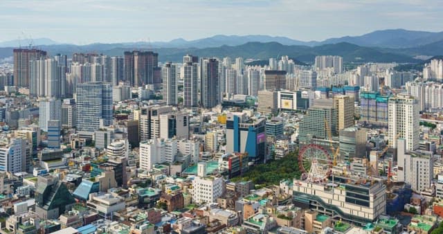 Busy scenery from day to sunset in downtown in Daegu with densely packed buildings