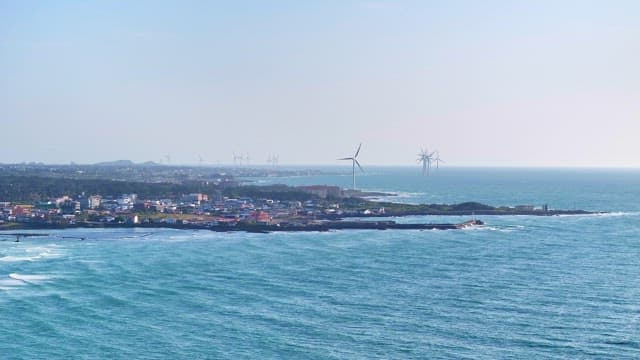 Coastal town with wind turbines and ocean