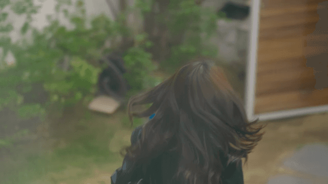 집을 나서며 미소 짓고 인사하는 여성