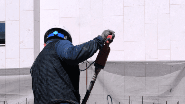 Construction worker using vibrator on concrete