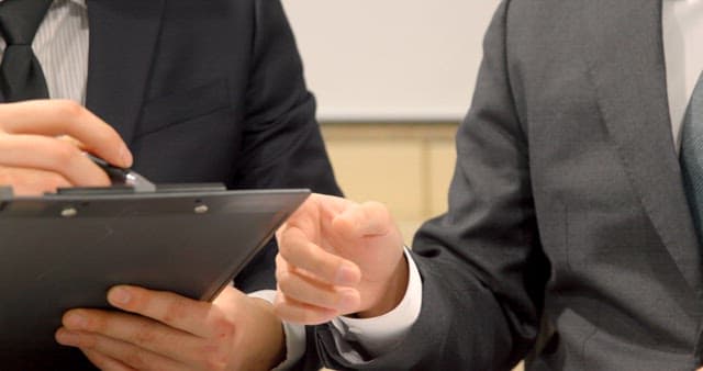 Businessman Listening to Colleagues and Taking Notes