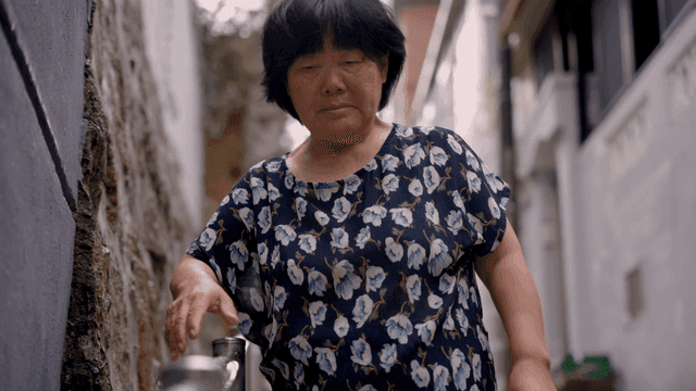 난간을 잡고 걷는 노인 여성