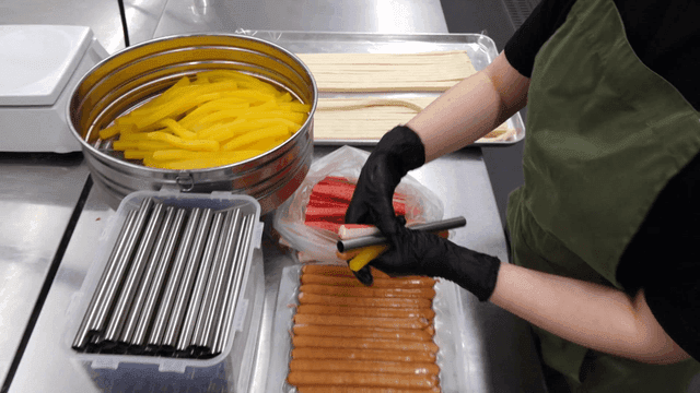 쇠막대와 김밥 속재료를 겹치는 요리사