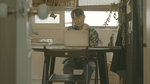 아늑한 주방에서 노트북으로 작업하는 사람