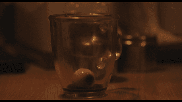 Eyeballs and blood pouring into glass