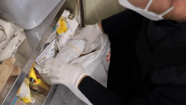 실내에서 쌀포대를 여는 사람