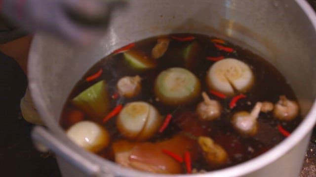 육수를 내기 위해 큰 냄비에 양파와 향신료를 끓이는 모습