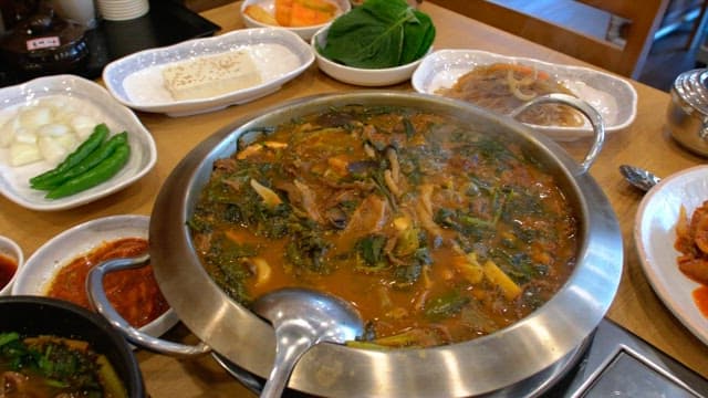 다양한 음식과 반찬이 푸짐하게 펼쳐진 식당의 테이블