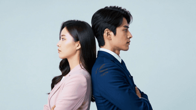 Man and woman in suits standing back-to-back