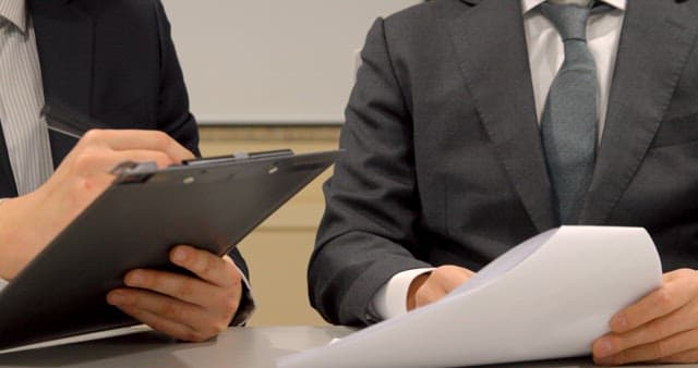 Businessmen Reviewing Documents with Conversation