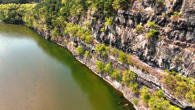 Serene river flowing beside rocky cliffs