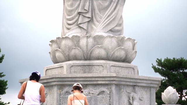 Large stone statue with visitors