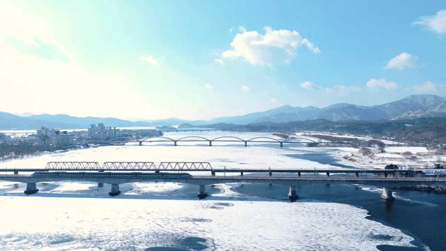 다리와 산이 있는 눈 덮인 강