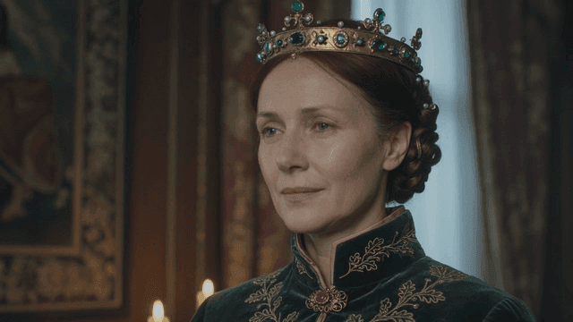 Queen wearing medieval European crown in dark room